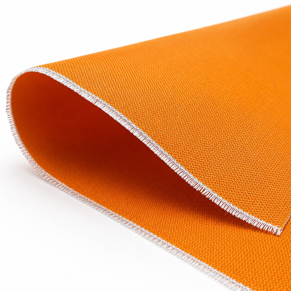 Close-up of orange silicone coated fiberglass fabric roll edge showing woven fiberglass structure and coating