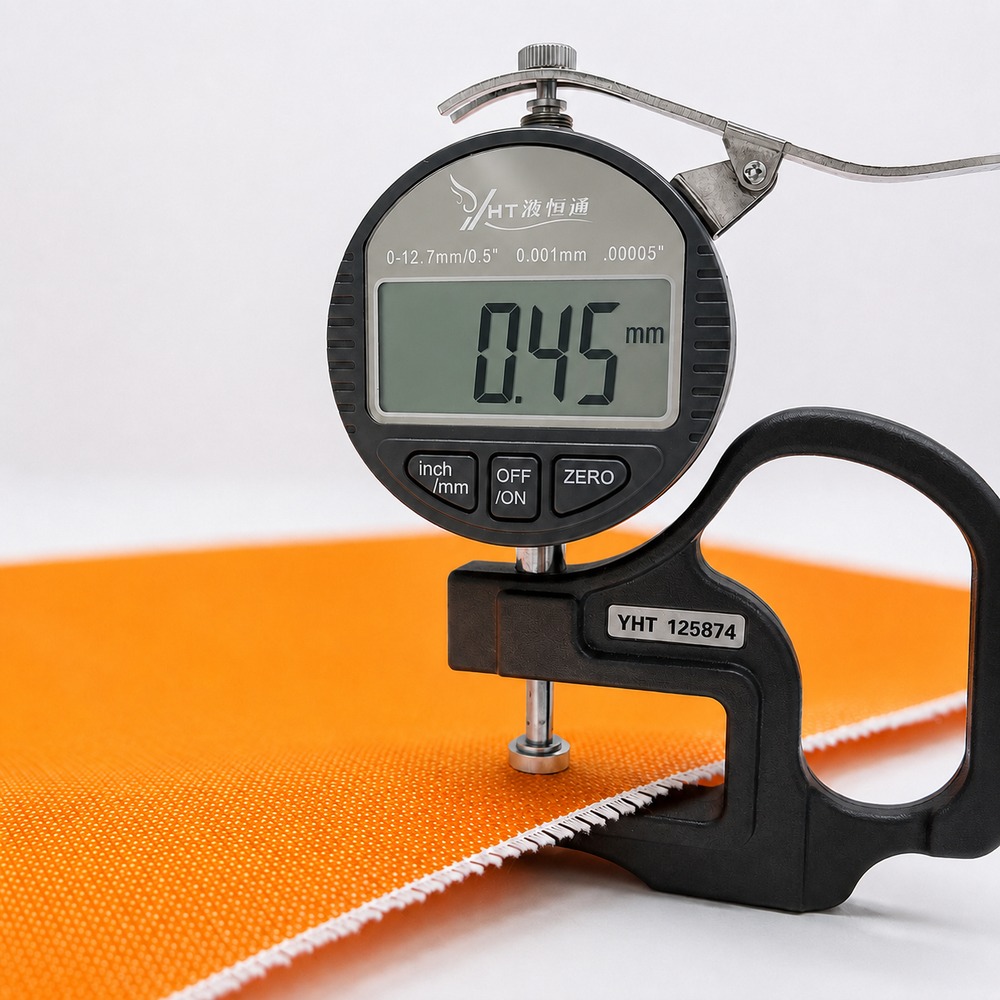 Digital thickness gauge measuring 0.45mm silicone coated fiberglass fabric for quality inspection